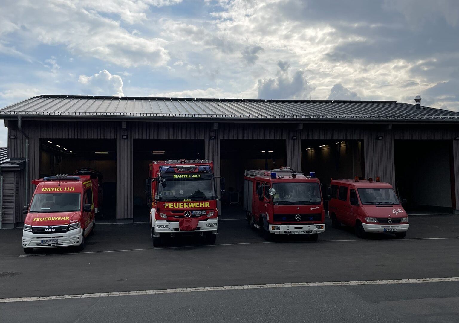 Vier Einsatzfahrzeuge der Freiwilligen Feuerwehr Mantel aufgereiht vor dem Gerätehaus